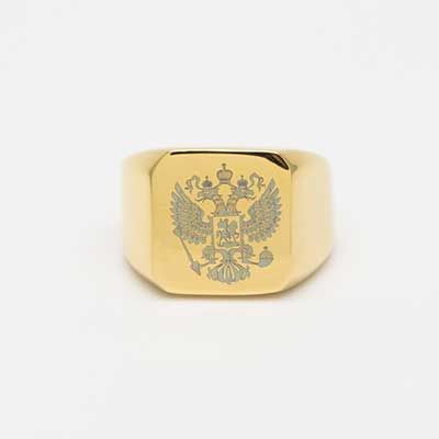 Men's gold ring with eagle crest engraved into the face.